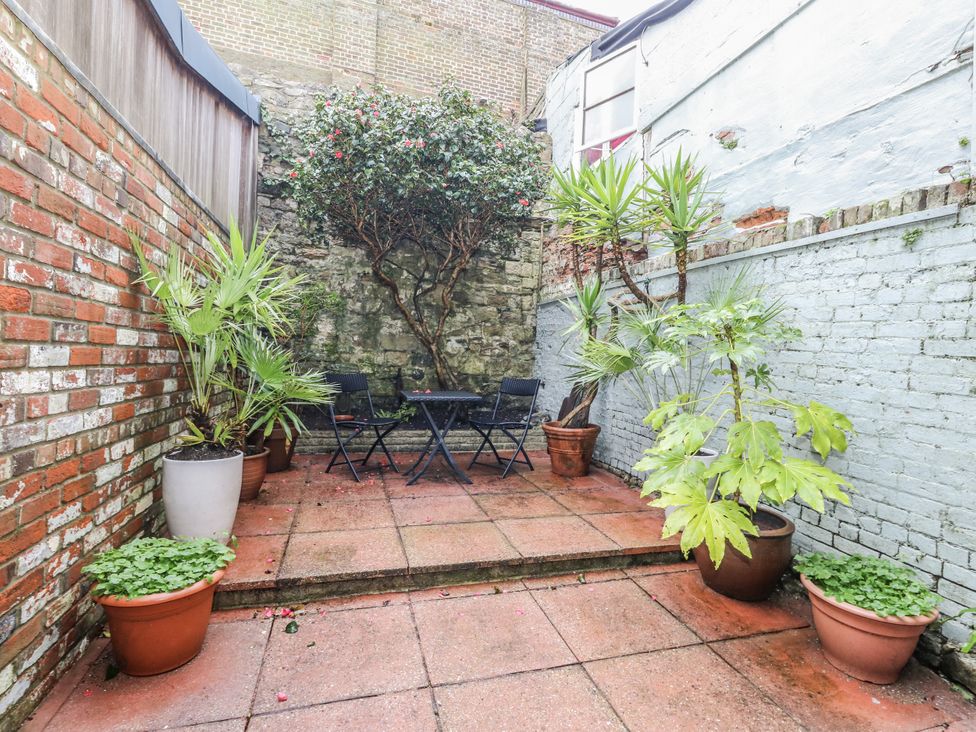 A garden area with potted plants and a patio table at Harbourside Weymouth
