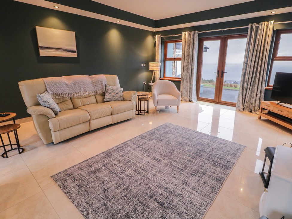 A living room with a sofa and television at Ard Na Mara in Drung near Quigley's Point, County Donegal