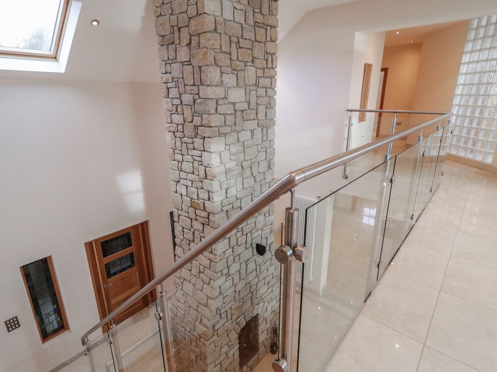 A hallway with stone wall and glass railing at Ard Na Mara Drung near Quigley's Point, County Donegal