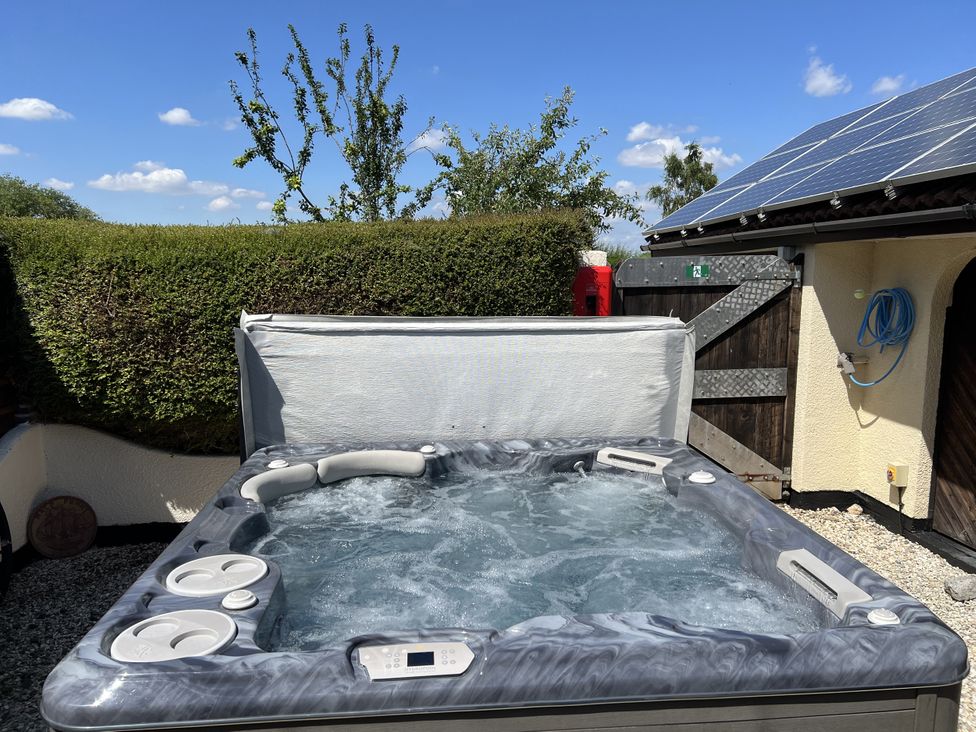 A hot tub with water and cover in an outdoor area at Sunnyside in Goxhill near Barrow-Upon-Humber