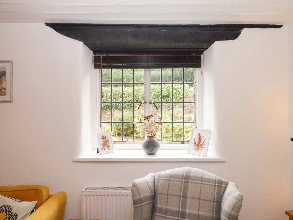 A living room with a window and decorative items at 2 New Mill Cottages North Bovey