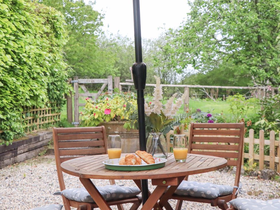 A table with croissants and drinks in a garden at 2 New Mill Cottages North Bovey