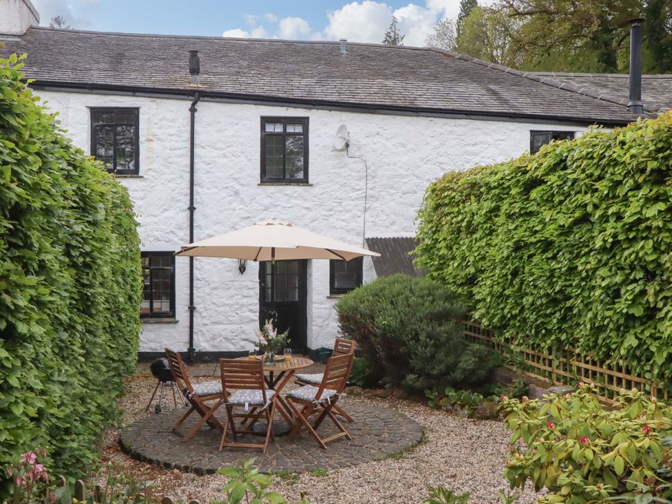 A garden with round table and chairs at 2 New Mill Cottages North Bovey