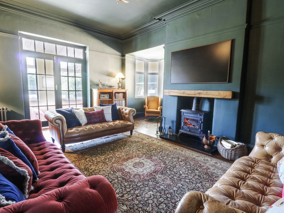 A living room with a sofa and fireplace at Glanrannell Park House in Llanwrda