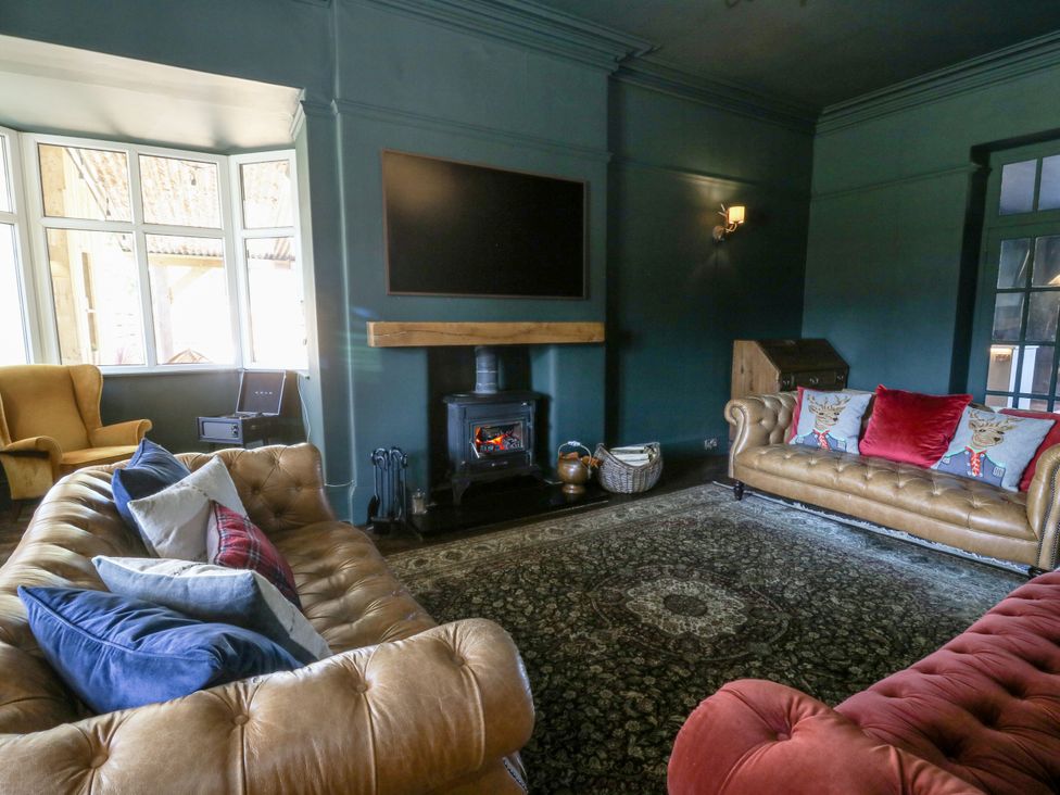 A living room with furniture and a fireplace at Glanrannell Park House in Llanwrda