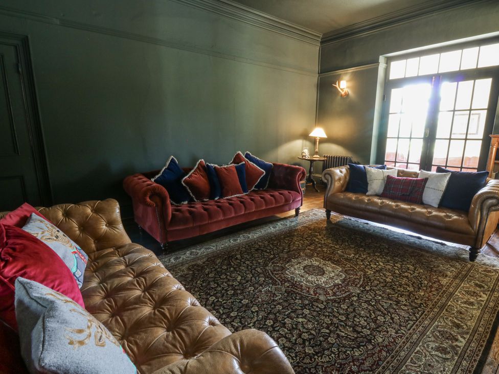 A living room with two sofas and a lamp at Glanrannell Park House in Llanwrda
