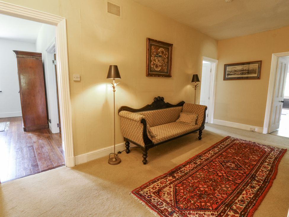 A hallway with a sofa and a lamp at Glanrannell Park House in Llanwrda