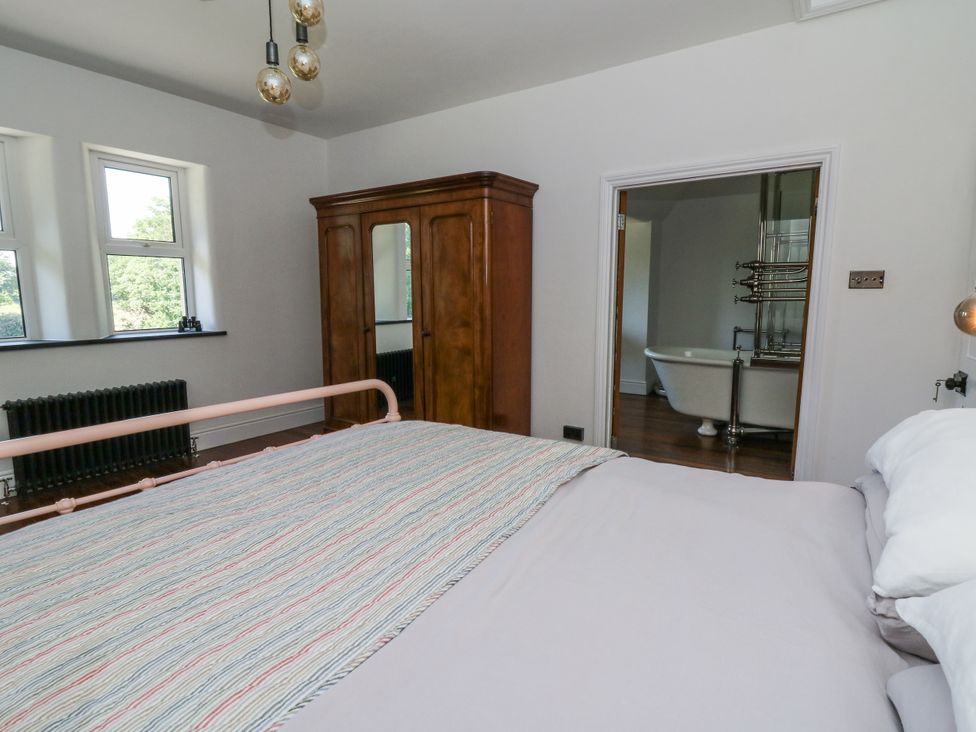 A bedroom with a bed and wardrobe at Glanrannell Park House in Llanwrda