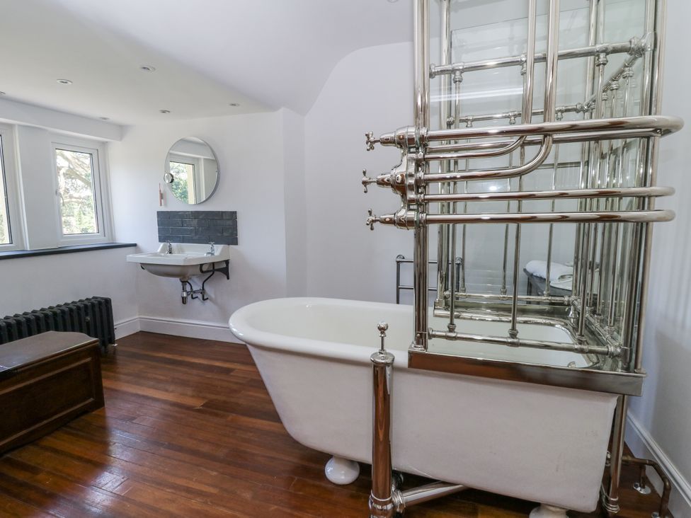 A bathroom with a bathtub and sink at Glanrannell Park House in Llanwrda