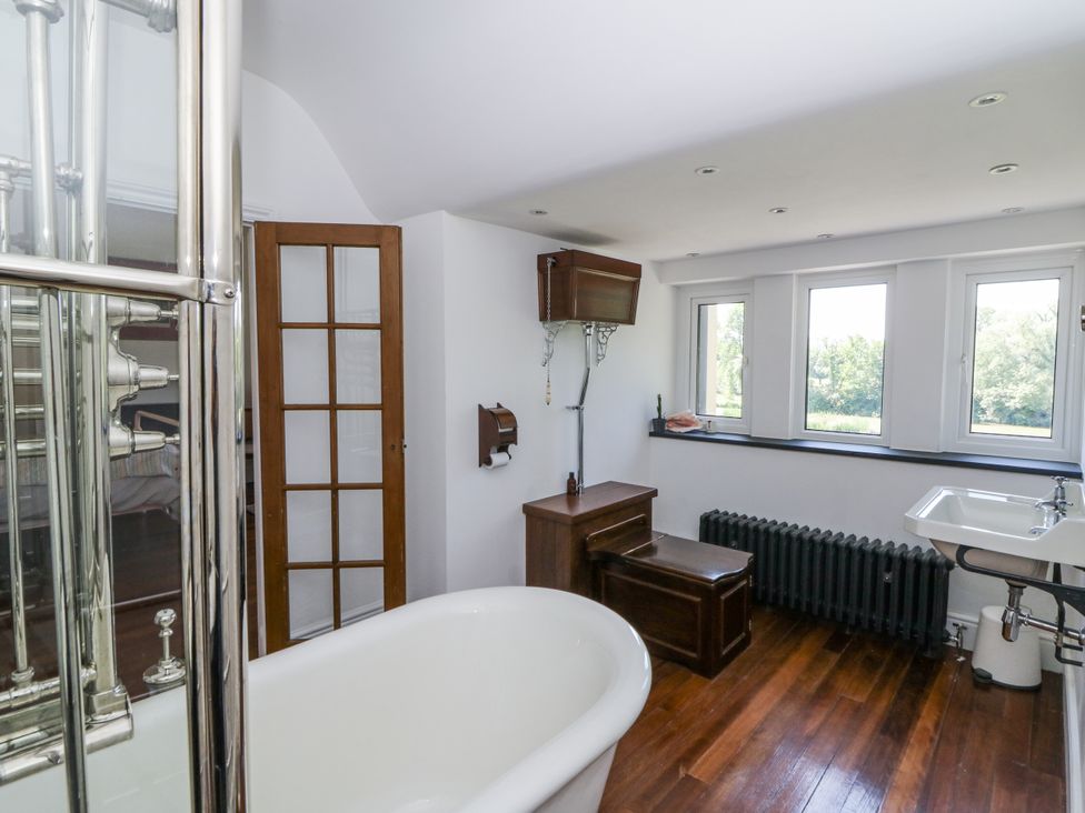 A bathroom featuring a bathtub, sink, and windows at Glanrannell Park House in Llanwrda