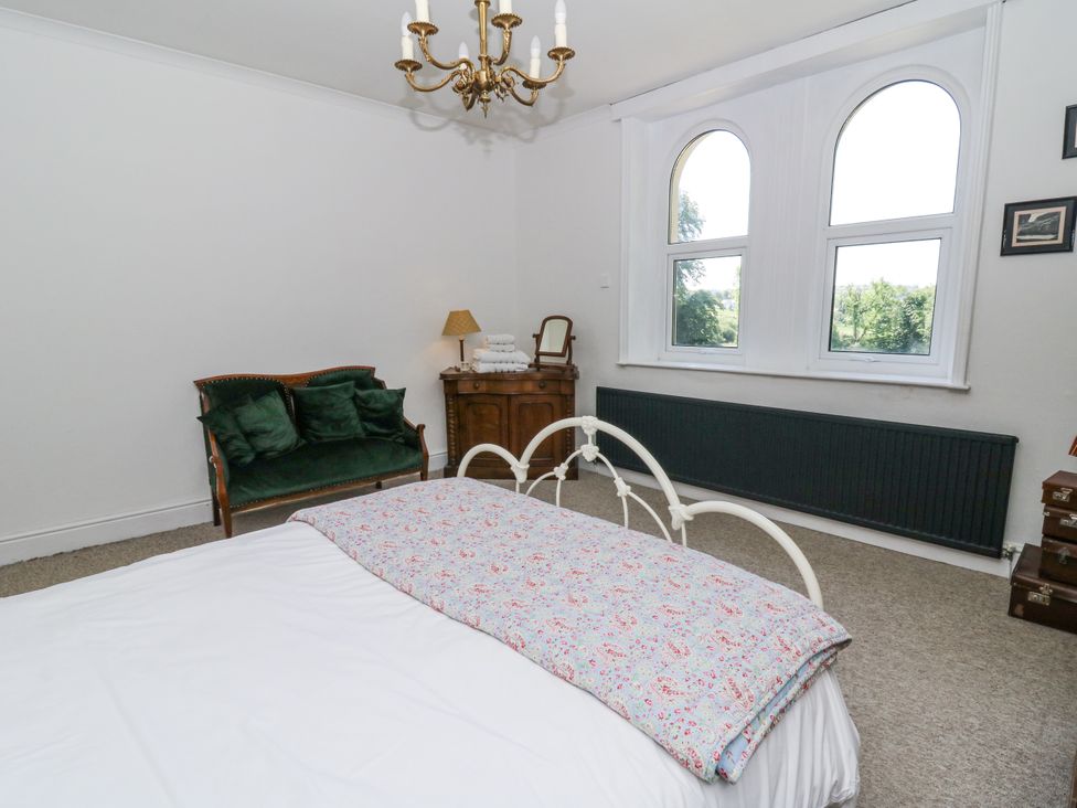 A bedroom with a bed and a sofa at Glanrannell Park House in Llanwrda