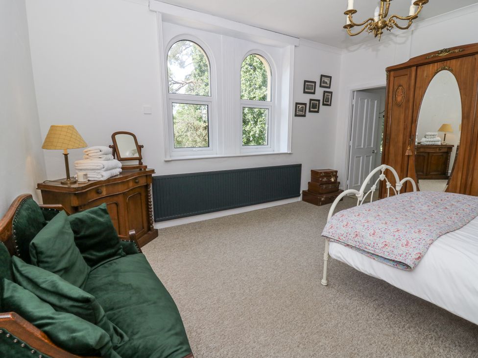 A bedroom with a bed and a sofa at Glanrannell Park House in Llanwrda