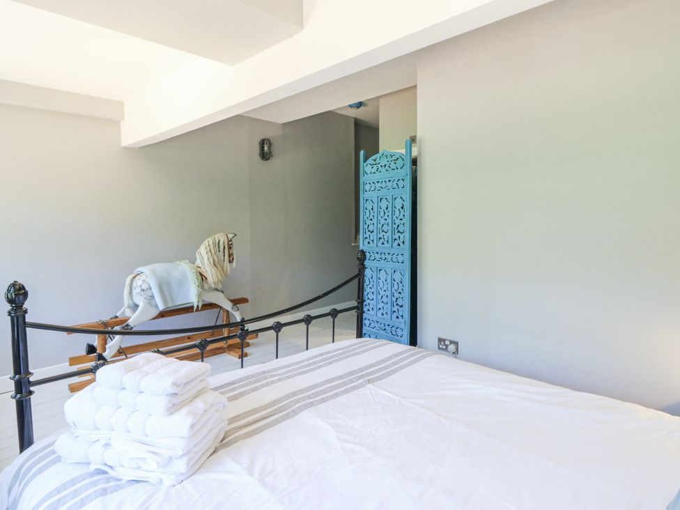 A bedroom with a bed and rocking horse at Glanrannell Park House in Llanwrda