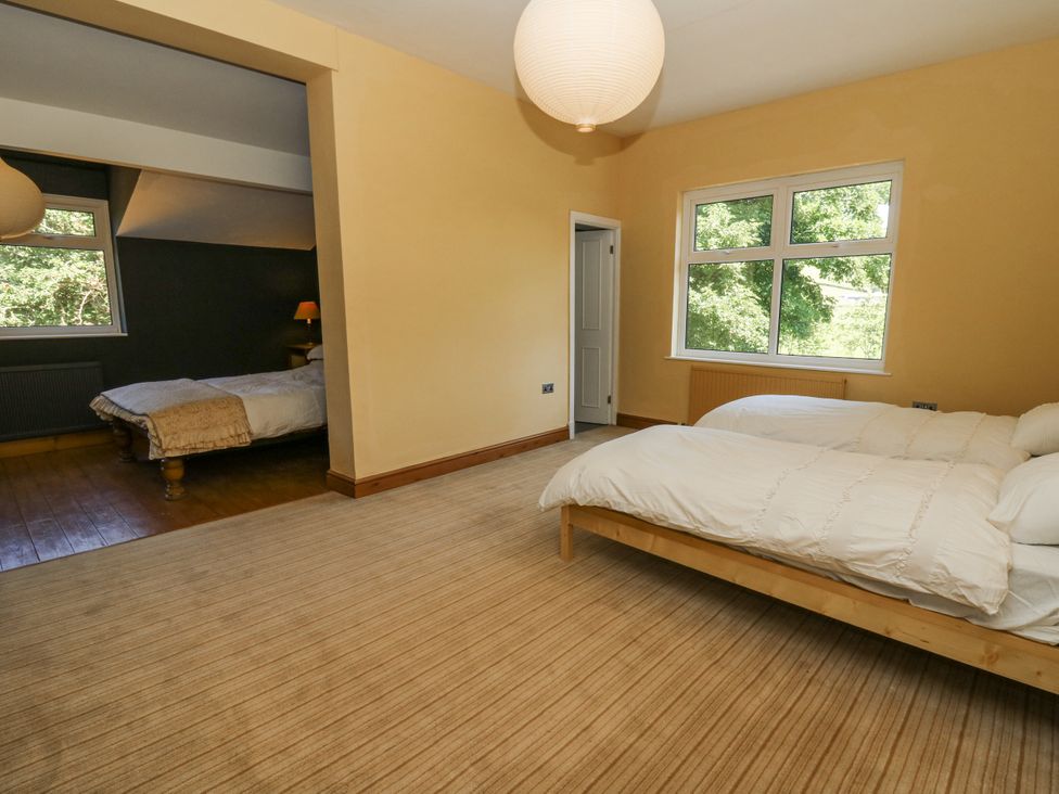 A bedroom with two beds and a window at Glanrannell Park House in Llanwrda