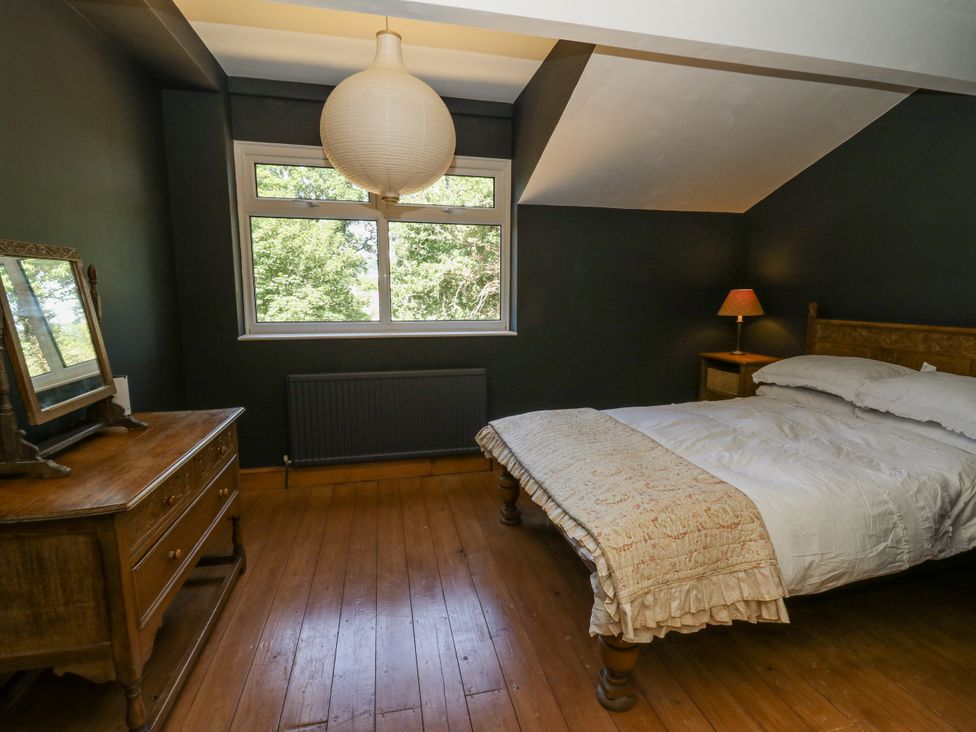 A bedroom with a bed and dresser at Glanrannell Park House in Llanwrda