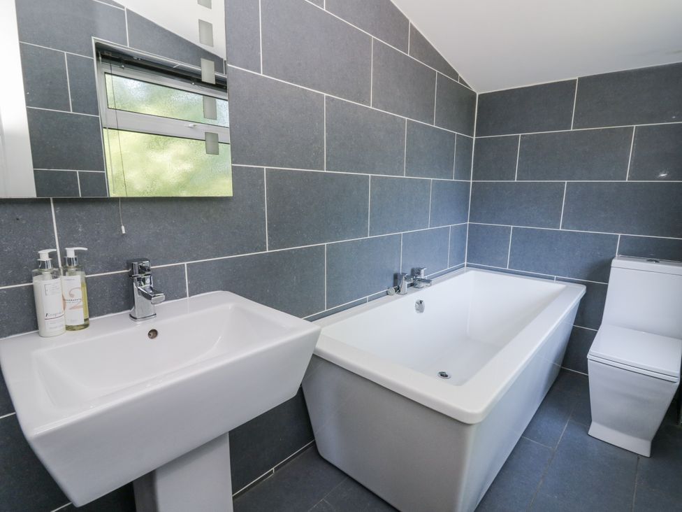 A bathroom with a bathtub, sink, and toilet at Glanrannell Park House, Llanwrda