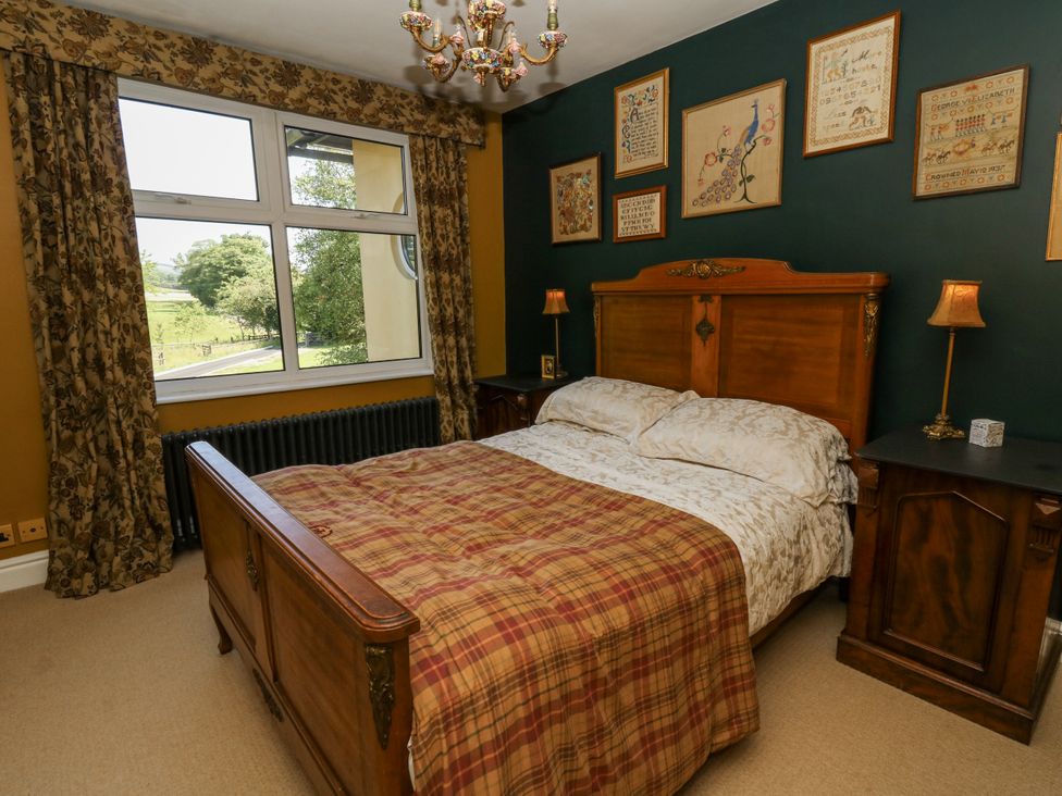 A bedroom with a bed and bedside tables at Glanrannell Park House in Llanwrda