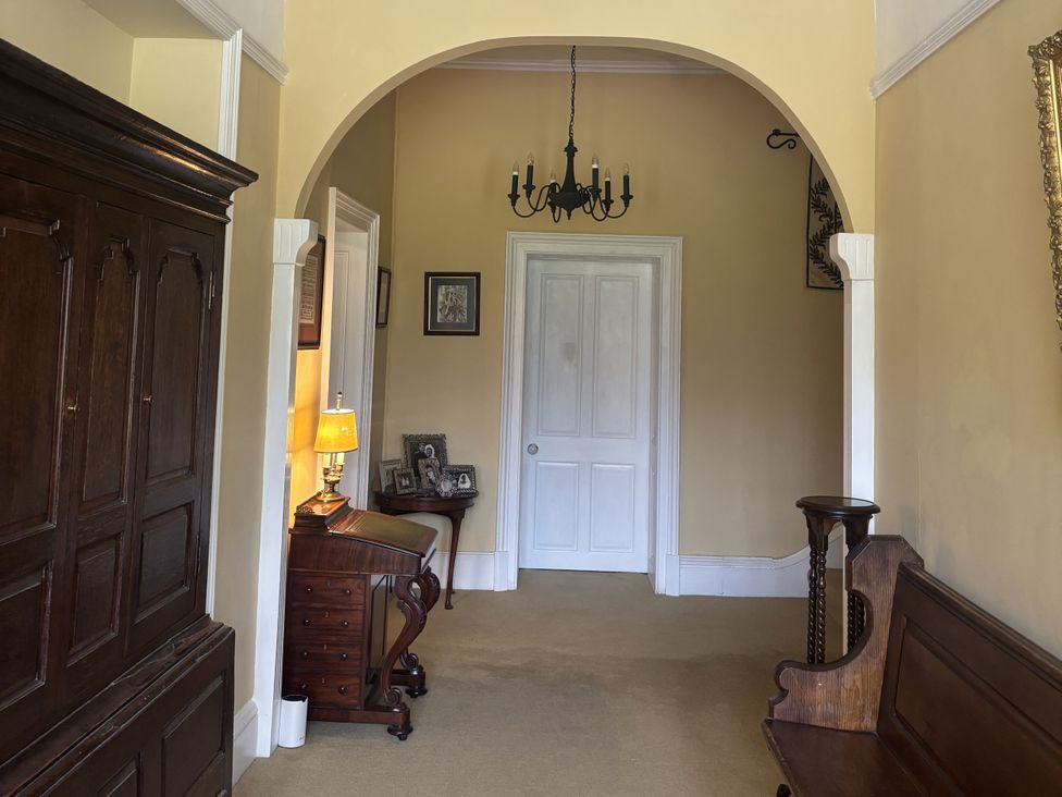 A hallway with a door and furniture at Glanrannell Park House Crugybar near Brechfa