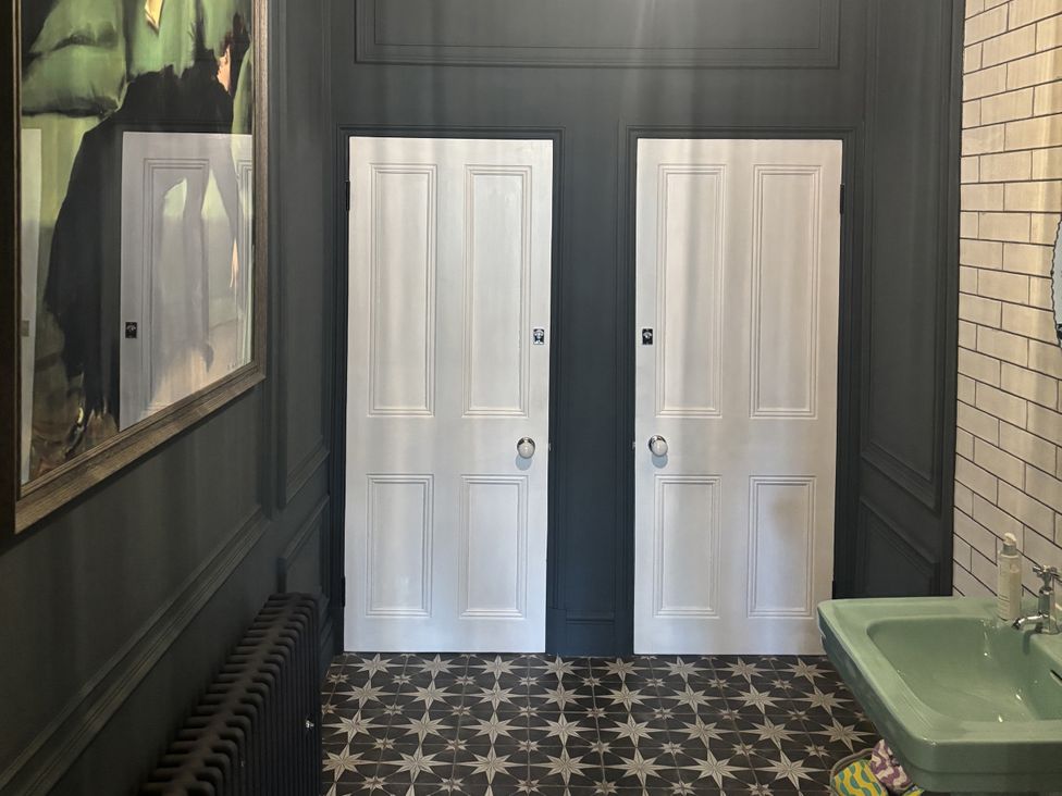 A bathroom with two doors and a green sink at Glanrannell Park House Crugybar near Brechfa