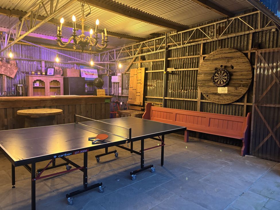 A game room with a ping pong table and a darts board at The Retreat at Glanrannell Park House Llansawel