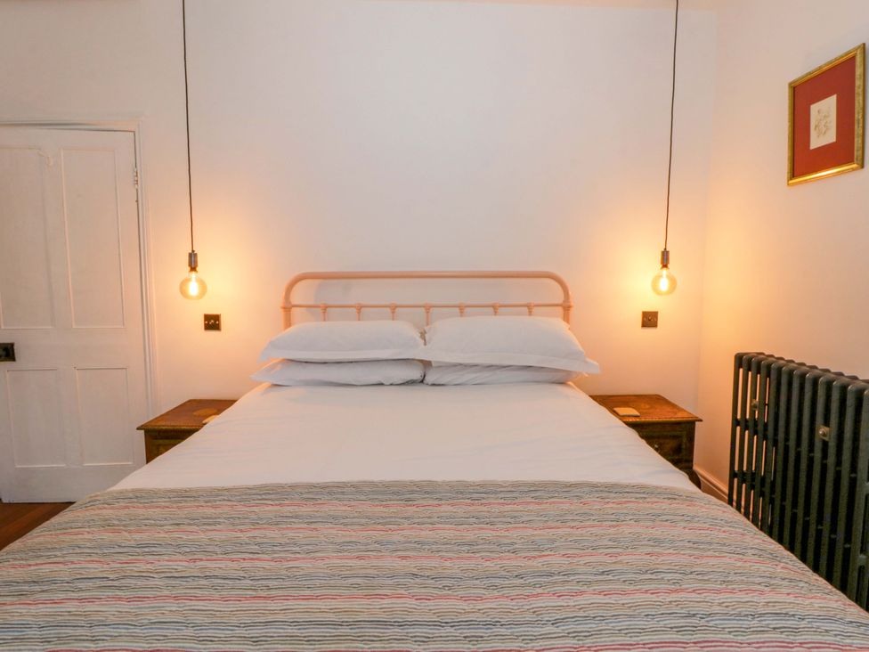 A bedroom with a bed and nightstand at The Retreat at Glanrannell Park House, Llansawel