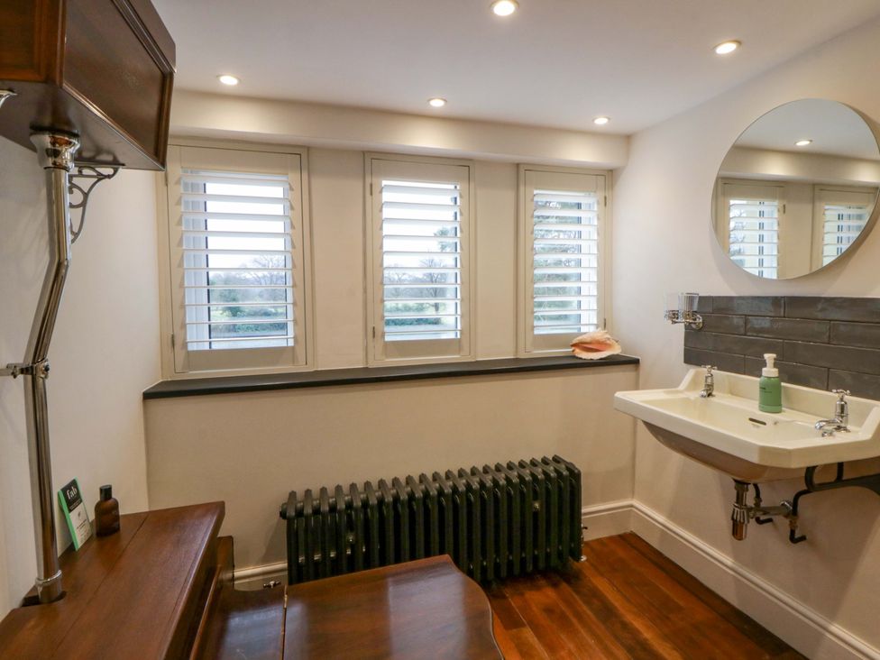 A bathroom with a sink and mirror at The Retreat at Glanrannell Park House in Llansawel