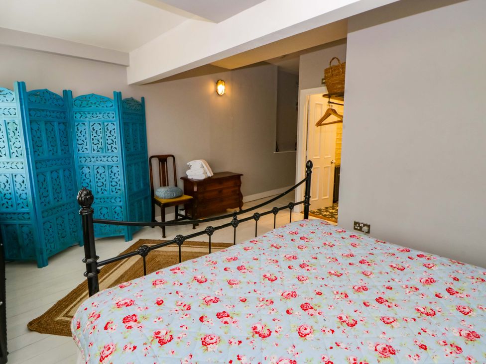 A bedroom with a bed and a blue screen at The Retreat at Glanrannell Park House in Llansawel
