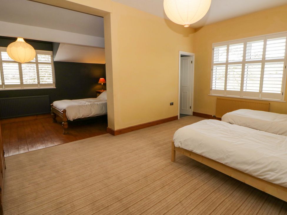 A bedroom with beds and lamps at The Retreat at Glanrannell Park House, Llansawel
