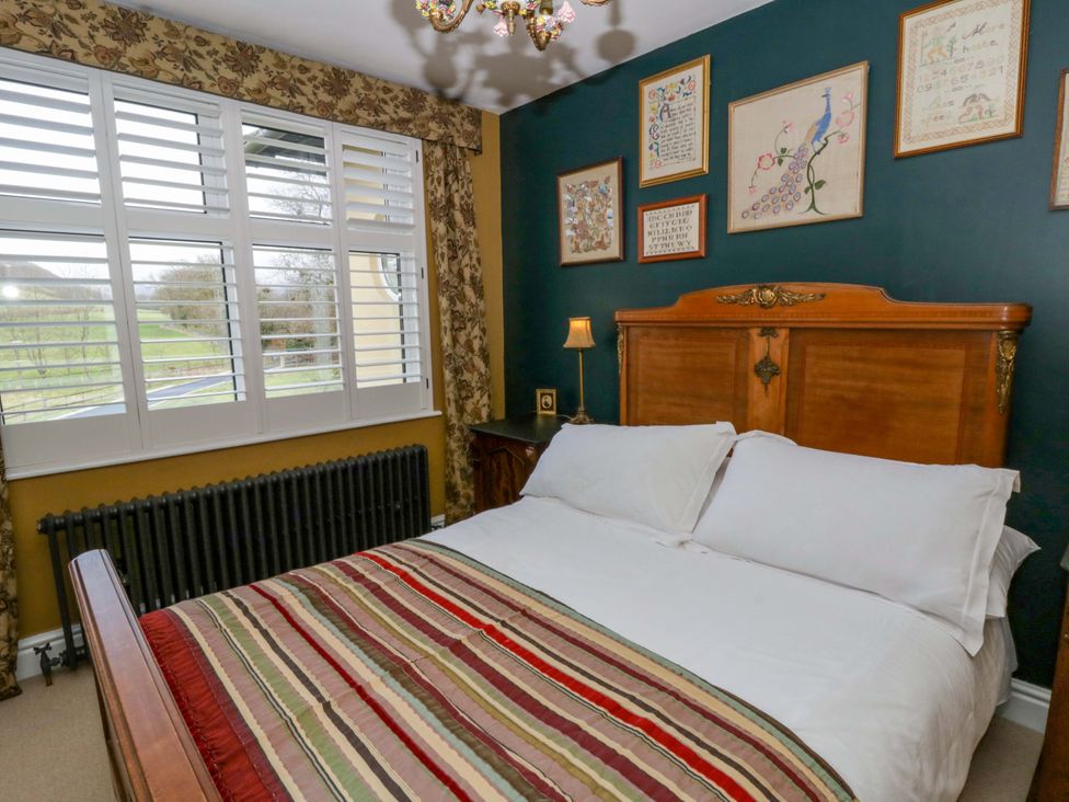 A bedroom with a bed and wall art at The Retreat at Glanrannell Park House Llansawel