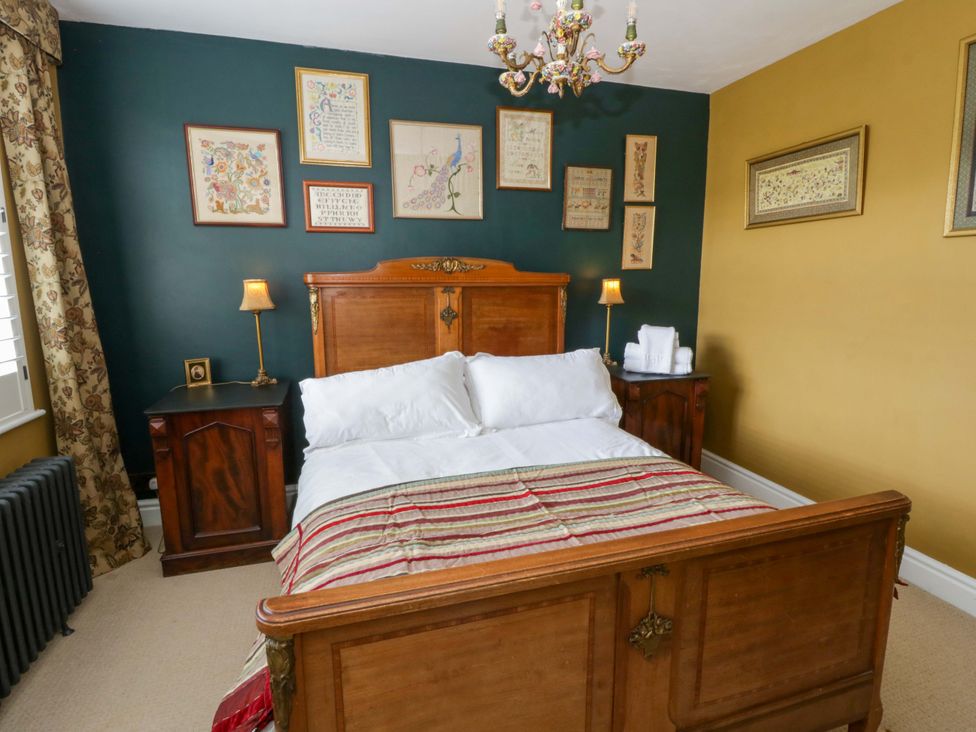 A bedroom with a wooden bed and side tables at The Retreat at Glanrannell Park House in Llansawel