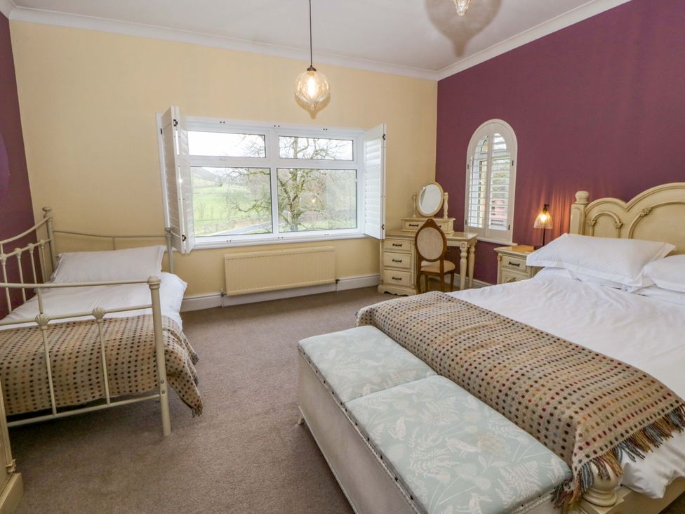 A bedroom with beds and a dresser at The Retreat at Glanrannell Park House in Llansawel