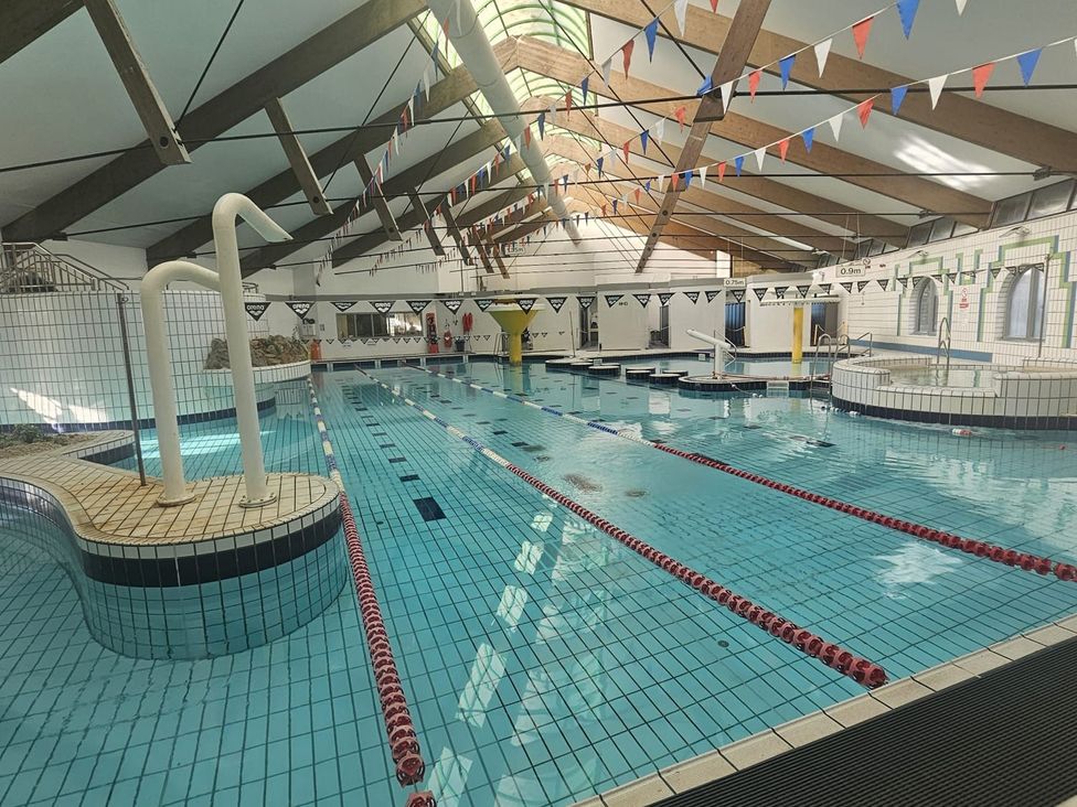A swimming pool with diving boards and lane markers at Valley Lodge 38 in St Ann's Chapel, Cornwall