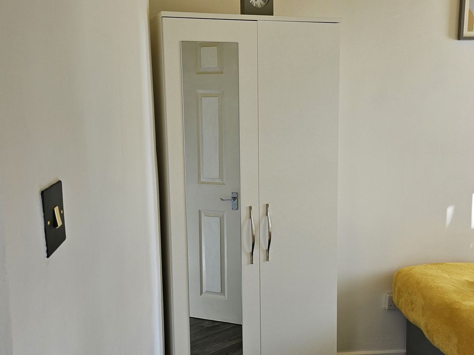 A bedroom with a wardrobe and a door at Anfield Stadium House in Liverpool