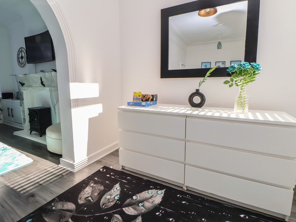 A living room with a dresser and flowers at Anfield Stadium House Liverpool