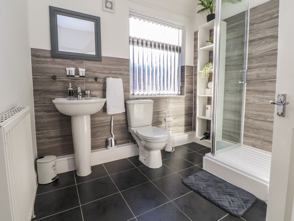 A bathroom with a sink, toilet, and shower at Anfield Stadium House in Liverpool