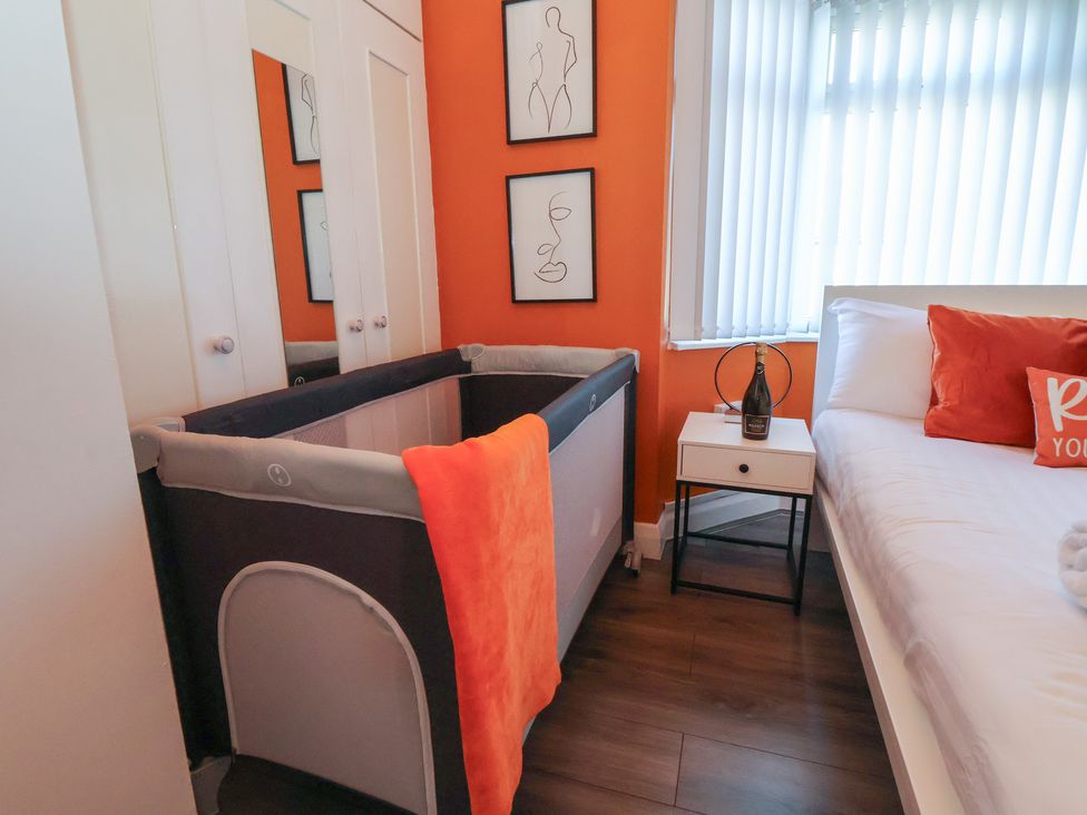 A bedroom with a crib and bed at Anfield Stadium House Liverpool