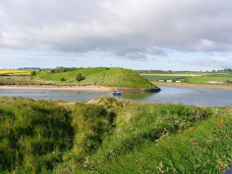 A boat on a river near a hill at Seafield Granary Alnmouth