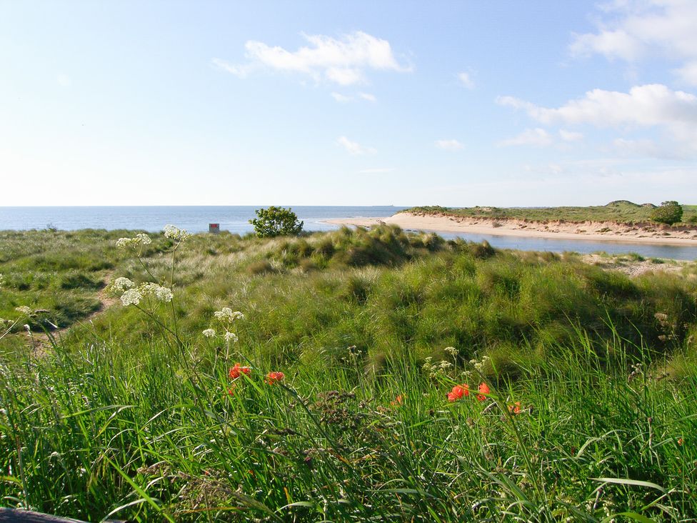 A view of sand dunes and a river near the sea at Seafield Granary Alnmouth
