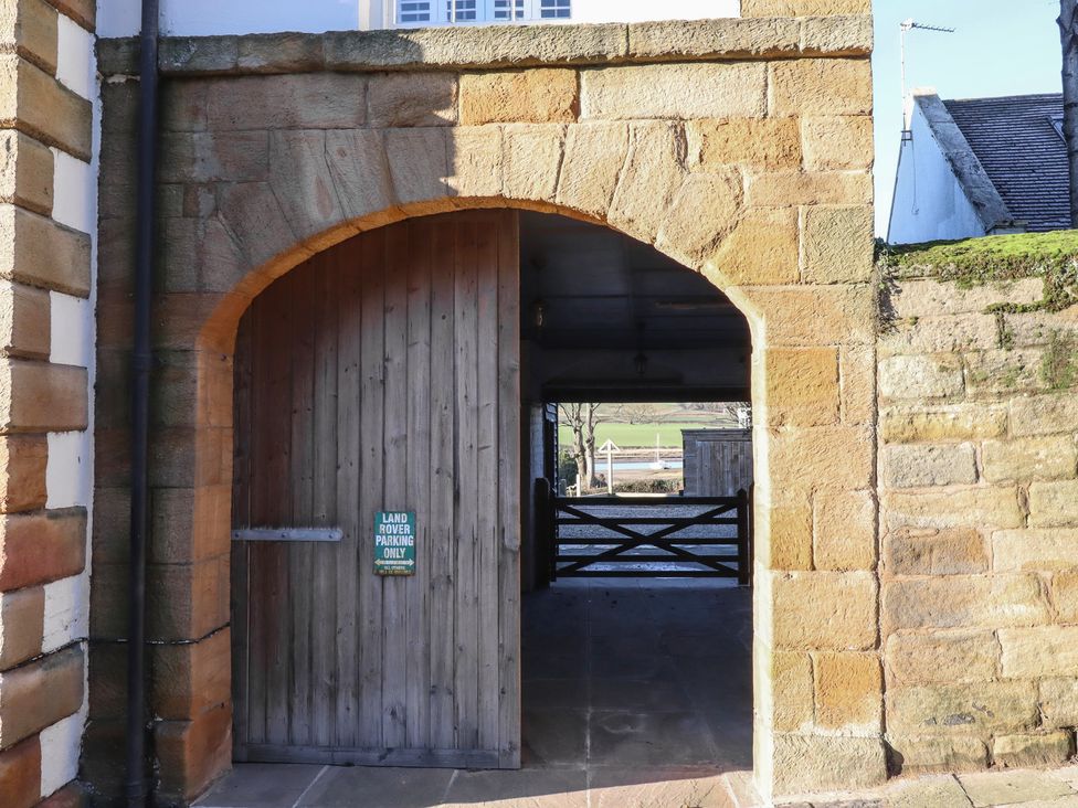An archway leading to a gated area with a parking sign at Seafield Granary Alnmouth