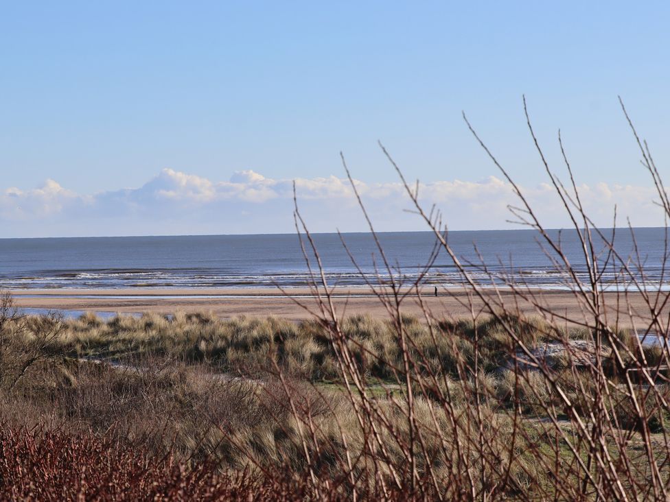 A beach view with dunes and water at Seafield Granary Alnmouth