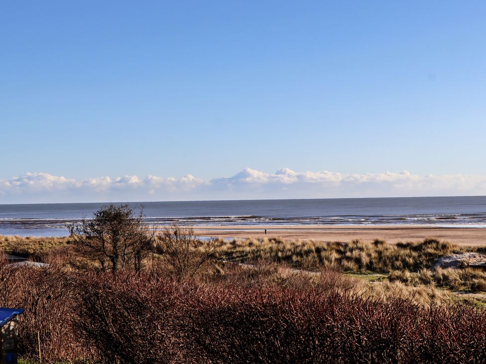 A beach view with sand and the ocean at Seafield Coach House in Alnmouth