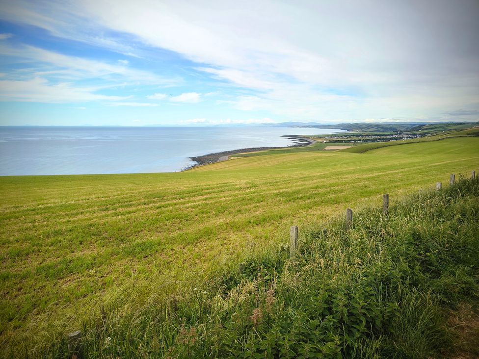 A view of the sea and grassland at Fir Tree Shepherd's Hut in Llanon
