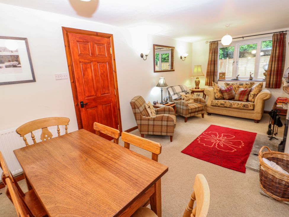 A living room with a dining table and sofas at Coldbeck Cottage in Ravenstonedale