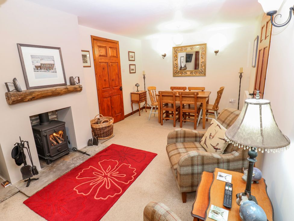 A dining room with a sofa and table at Coldbeck Cottage in Ravenstonedale