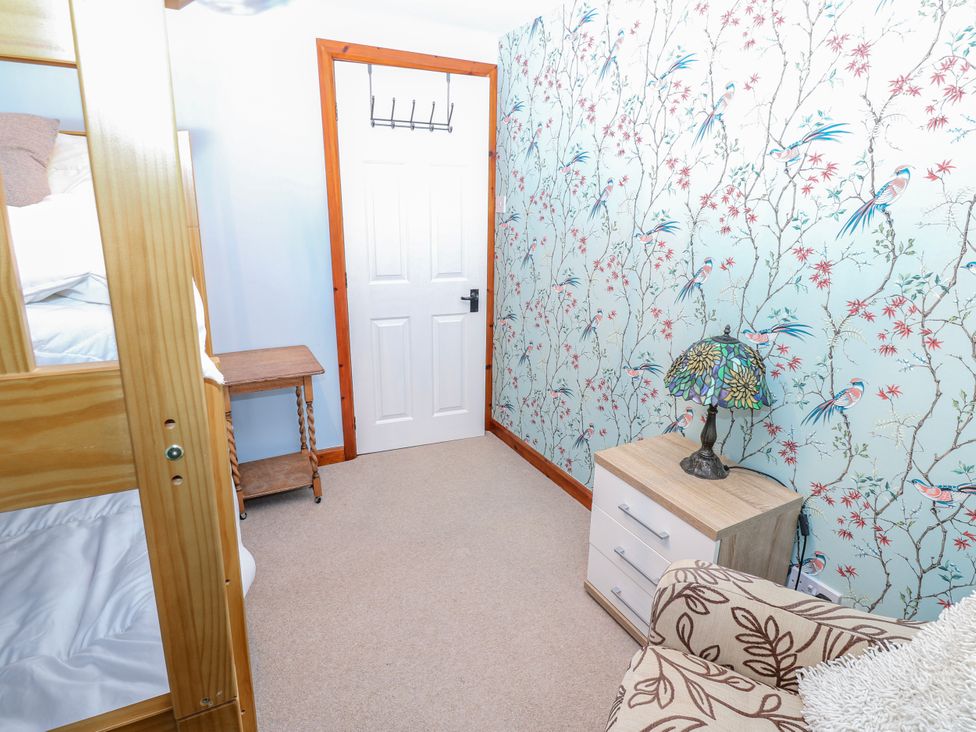 A bedroom with bunk bed and patterned wallpaper at Coldbeck Cottage in Ravenstonedale