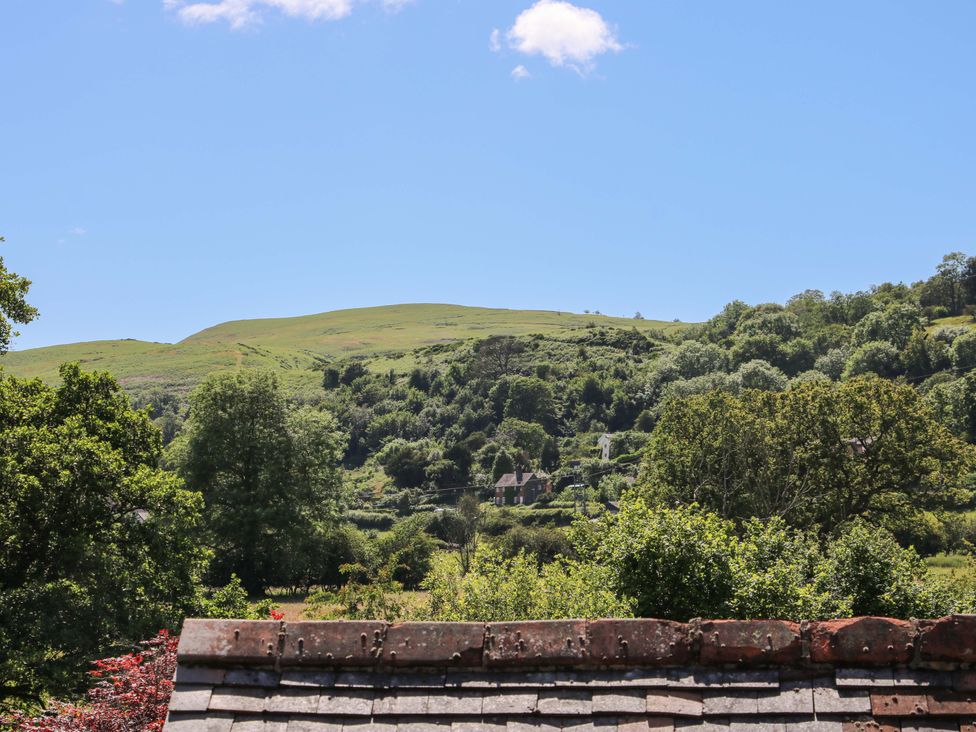 A view of hills and trees with a roof in the foreground at The Miller’s Roost at Dudgeley Mill All Stretton near Church Stretton