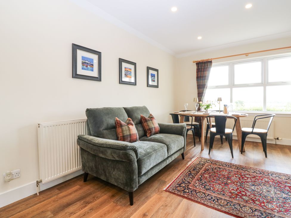 A living room with a sofa and dining table at Top Cottage in Cupar, Fife
