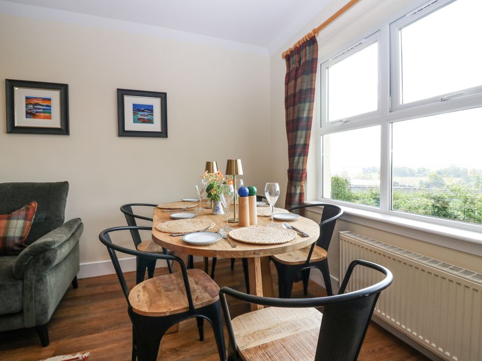 A dining room with a table set for meals at Top Cottage in Cupar, Fife