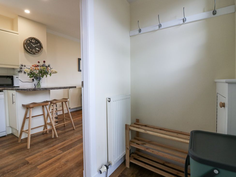 A kitchen area with bar stools and flowers at Top Cottage in Cupar, Fife
