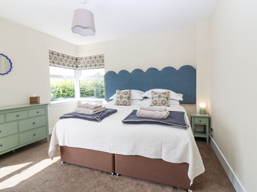 A bedroom with a bed and dresser at Top Cottage in Cupar, Fife